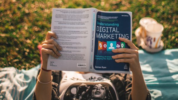 Person reading Digital Marketing book.